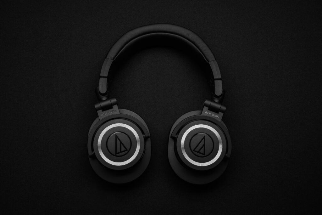 Top 10 Gifts for Tech-Loving Dads (2025 Edition) Close-up of black over-ear headphones on a black background, showcasing modern design.